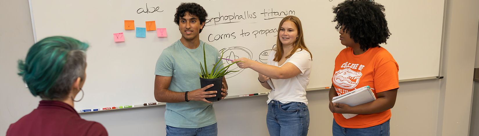 三名学生向教职员工作了演讲。一个学生占有植物，而另一个学生则在植物的某些地方。