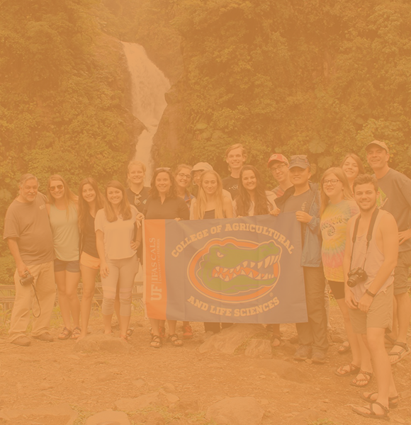 在哥斯达黎加出国留学的学生，在瀑布前面摆着UF国旗 