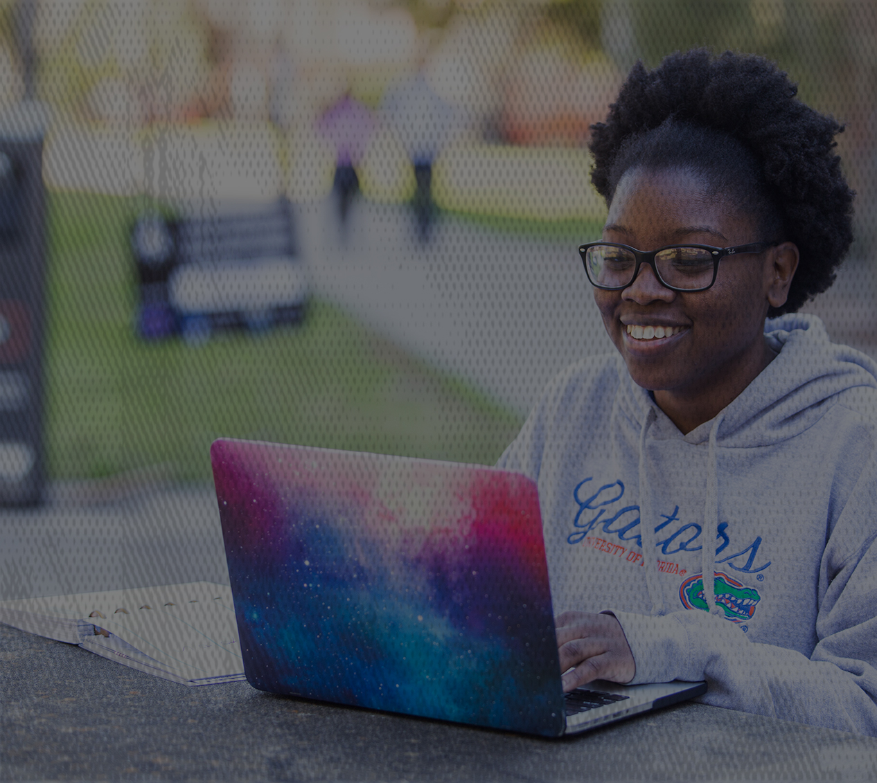 Cals远程教育学生坐在长凳上，她的五彩笔记本电脑。 
